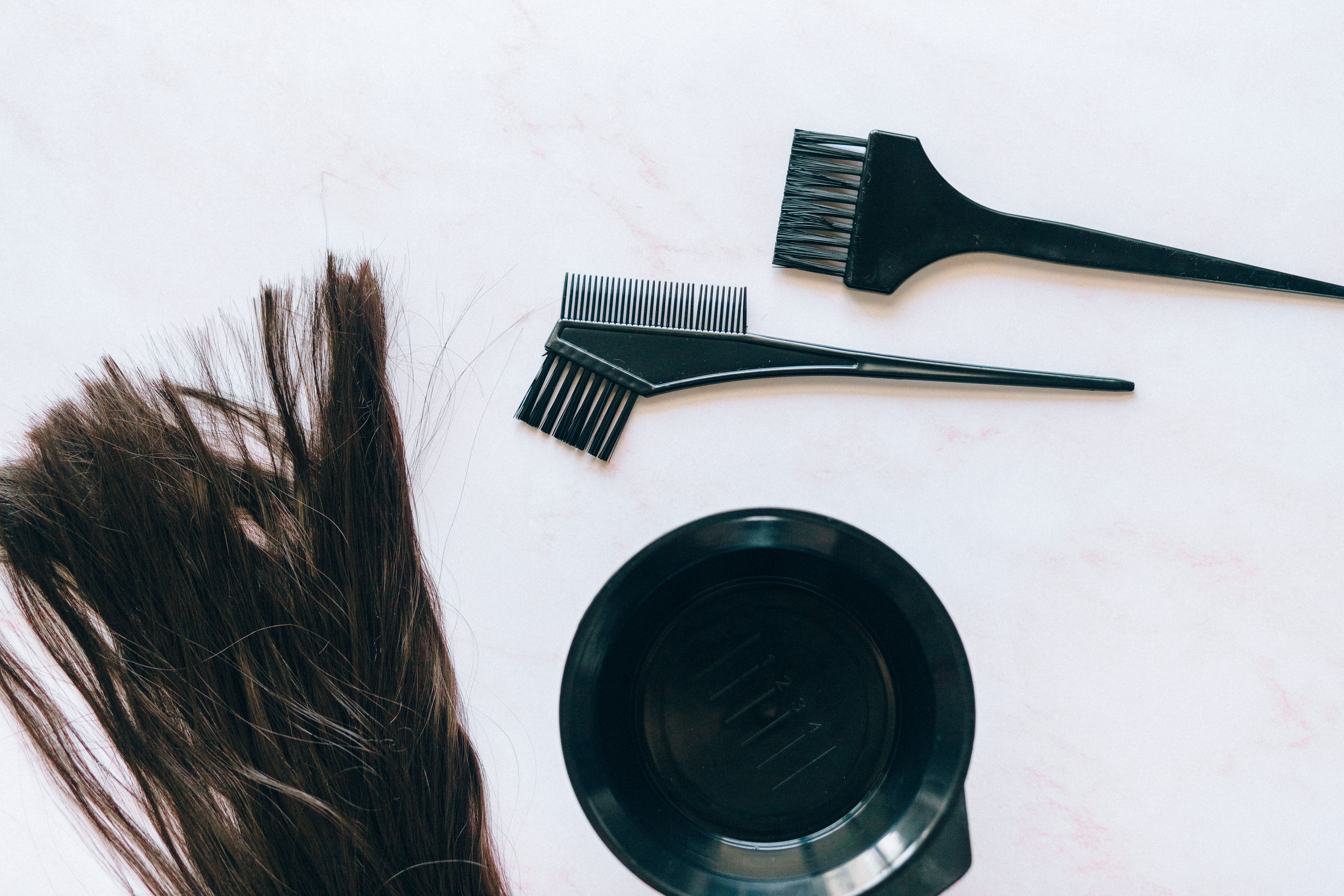 Hair coloring tools and strands of hair arranged for shade matching on a white background